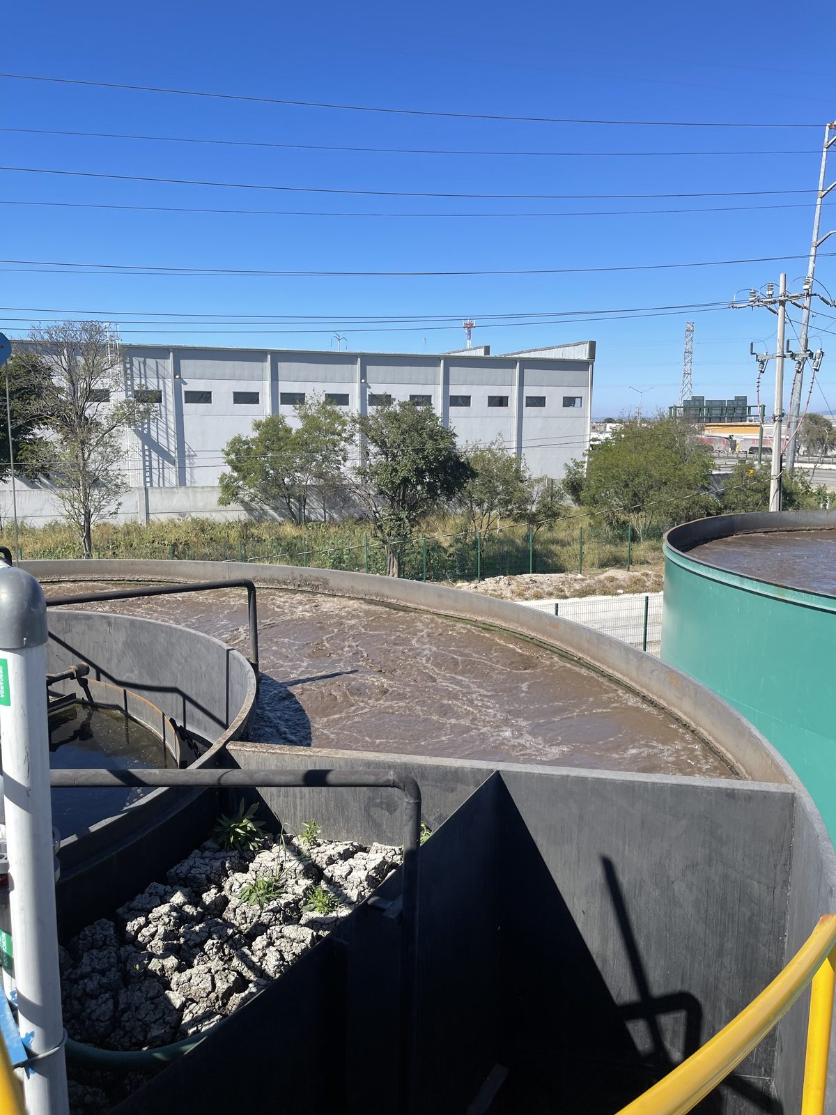 Clarificador con puente de rastras en operación dentro de una planta de tratamiento